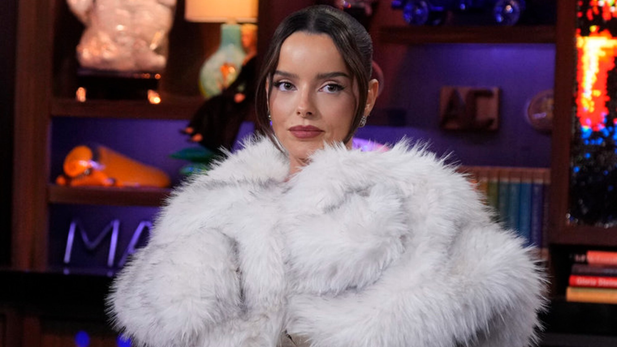 Maura Higgins wearing a big white fur as a guest on Watch What Happens Live.