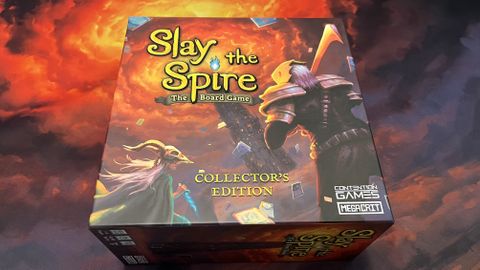 Photograph of Slay the Spire the board game with a slay the spire playmat behind it