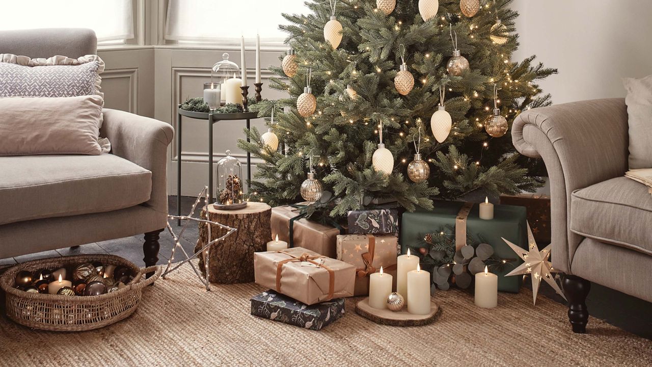 christmas tree and presents, candles and baubles beneath in a basket