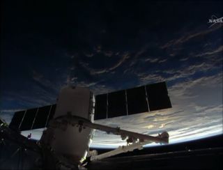 A space sunrise casts light on the Earth as astronauts attach a SpaceX Dragon spacecraft to the International Space Station on April 20, 2014. The Dragon cargo ship delivered about 5,000 lbs. of supplies to the station.