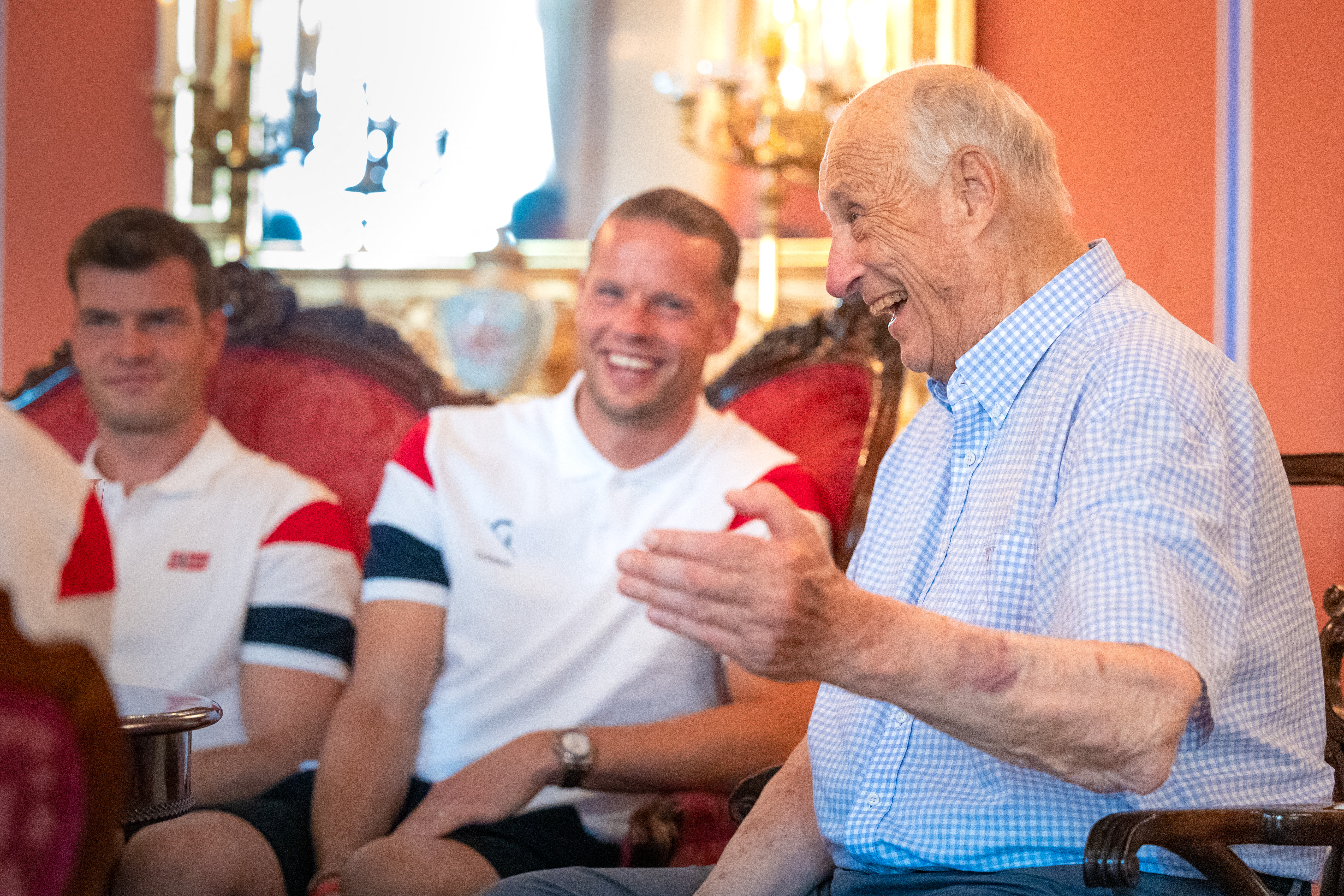 King Harald laughing with members of the Norwegian World Cup soccer team