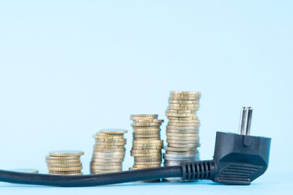 Several piles of coins and a power cable on a blue background
