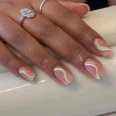 A pastel green and pink swirl nail design