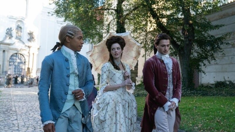 Kelvin Harrison Jr., Samara Weaving and Alex Fizalan walking in garden in Chevalier