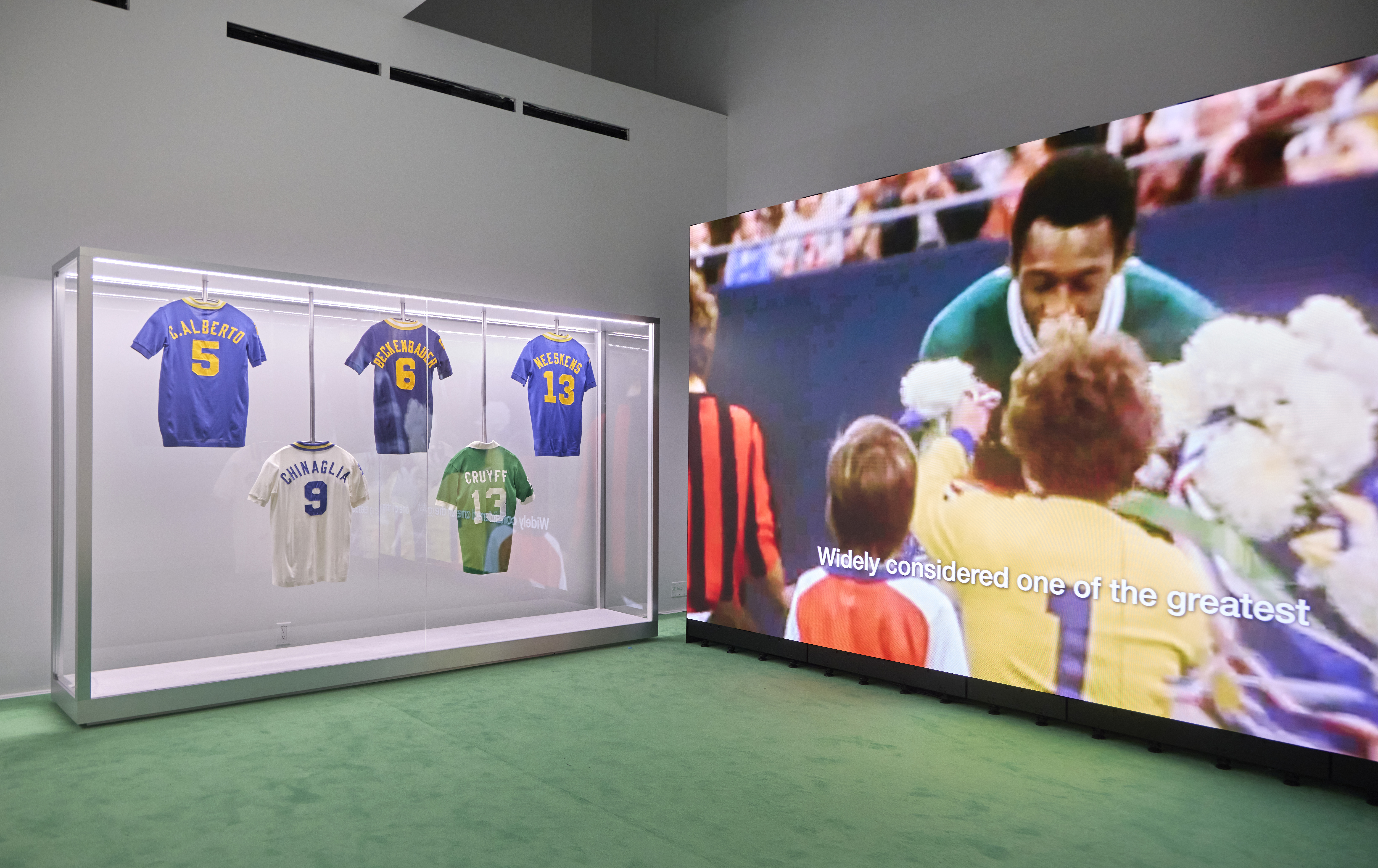Football jerseys on display beside video installation at Home of Football: Home &amp;amp; Away
