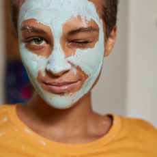 Woman with face mask on, winking at camera