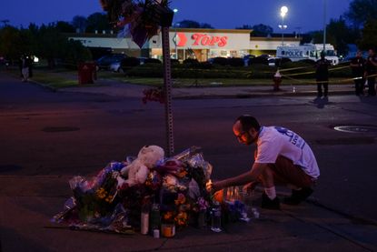 A community member tends to a memorial outside of a Tops supermarket in Buffalo.