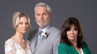 EastEnders' Kathy Beale in a wedding dress, Rocky Cotton in a grey wedding suit and Jo Cotton smirking in a green blazer.