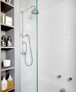 Tall grey shelves next to bath and shower