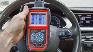 Mechanic using a handheld device to check OBD codes