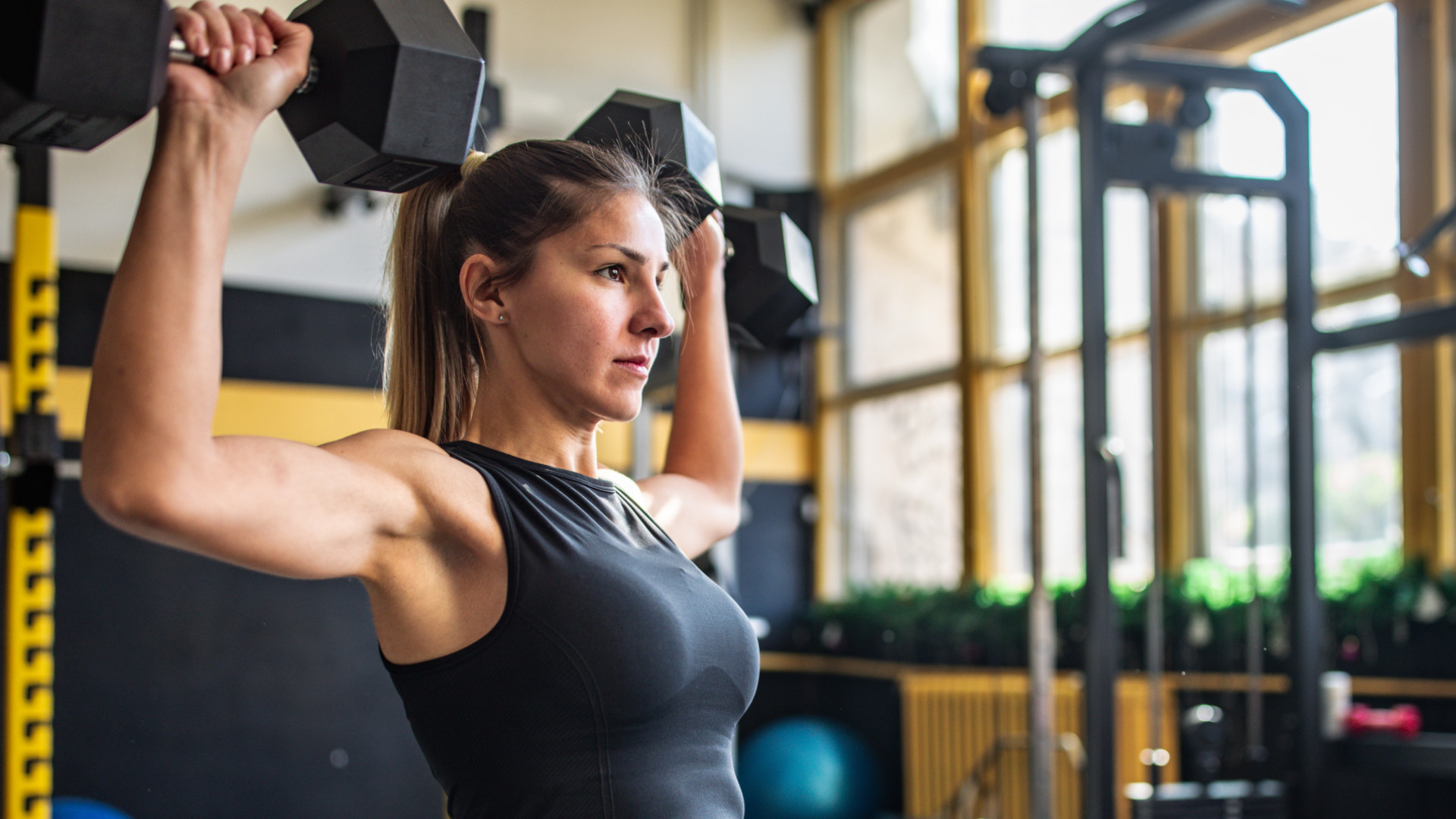 A woman doing dumbbell shoulder press
