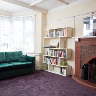 Living room with green sofa and white bookcase