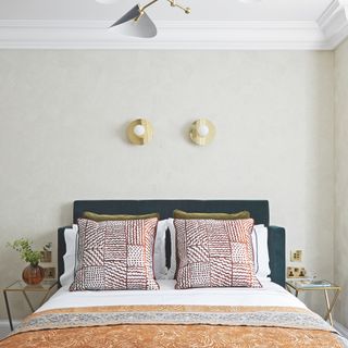 Neutral bedroom with two metallic wall lights above bed