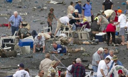 People rush to help injured spectators following the deadly crash Friday of a vintage World War II fighter jet at the annual Reno, Nev. air competition.