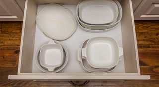 White cookware in a kitchen drawer