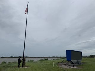 Security officials raise the American flag over the Kennedy Space Center's Launch Complex 39 in Cape Canaveral, Florida on Sept. 4, 2019 after a glancing blow from Hurricane Dorian.