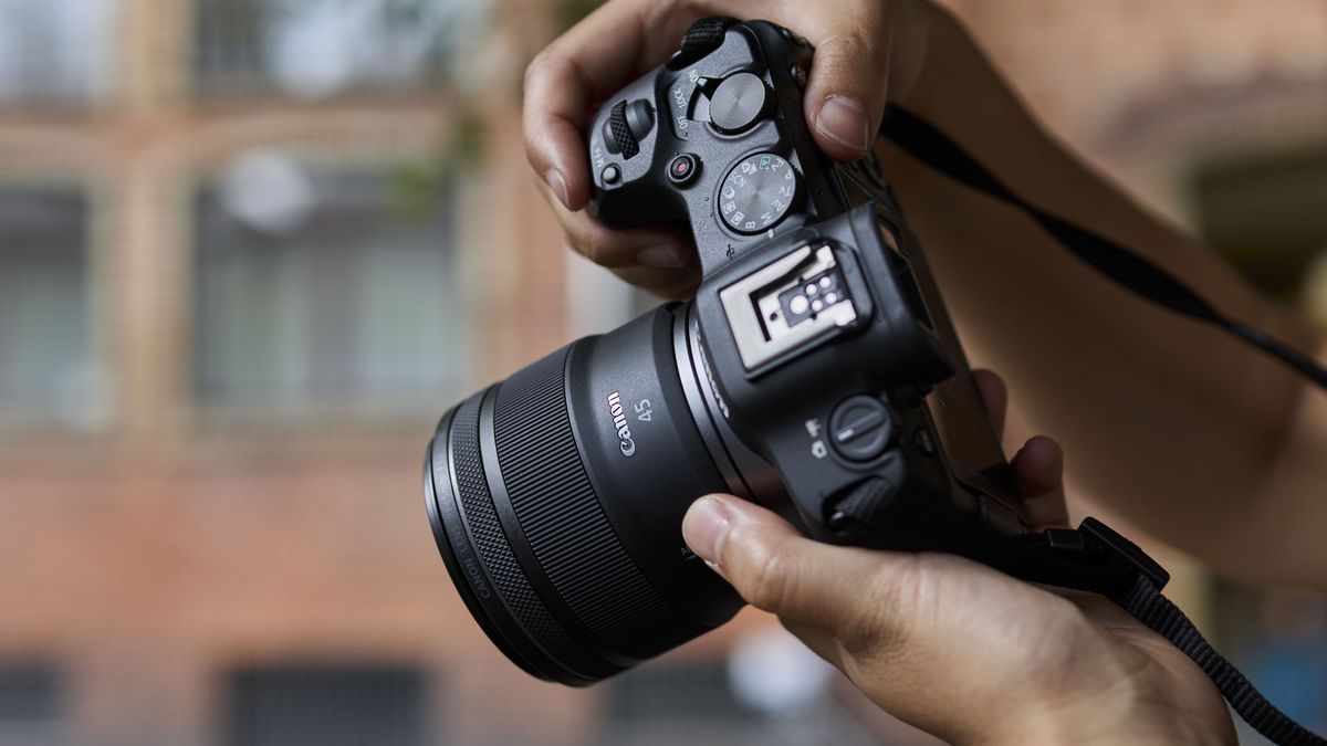 Canon RF 45mm F1.2 STM lens in the hand, attached to a Canon camera