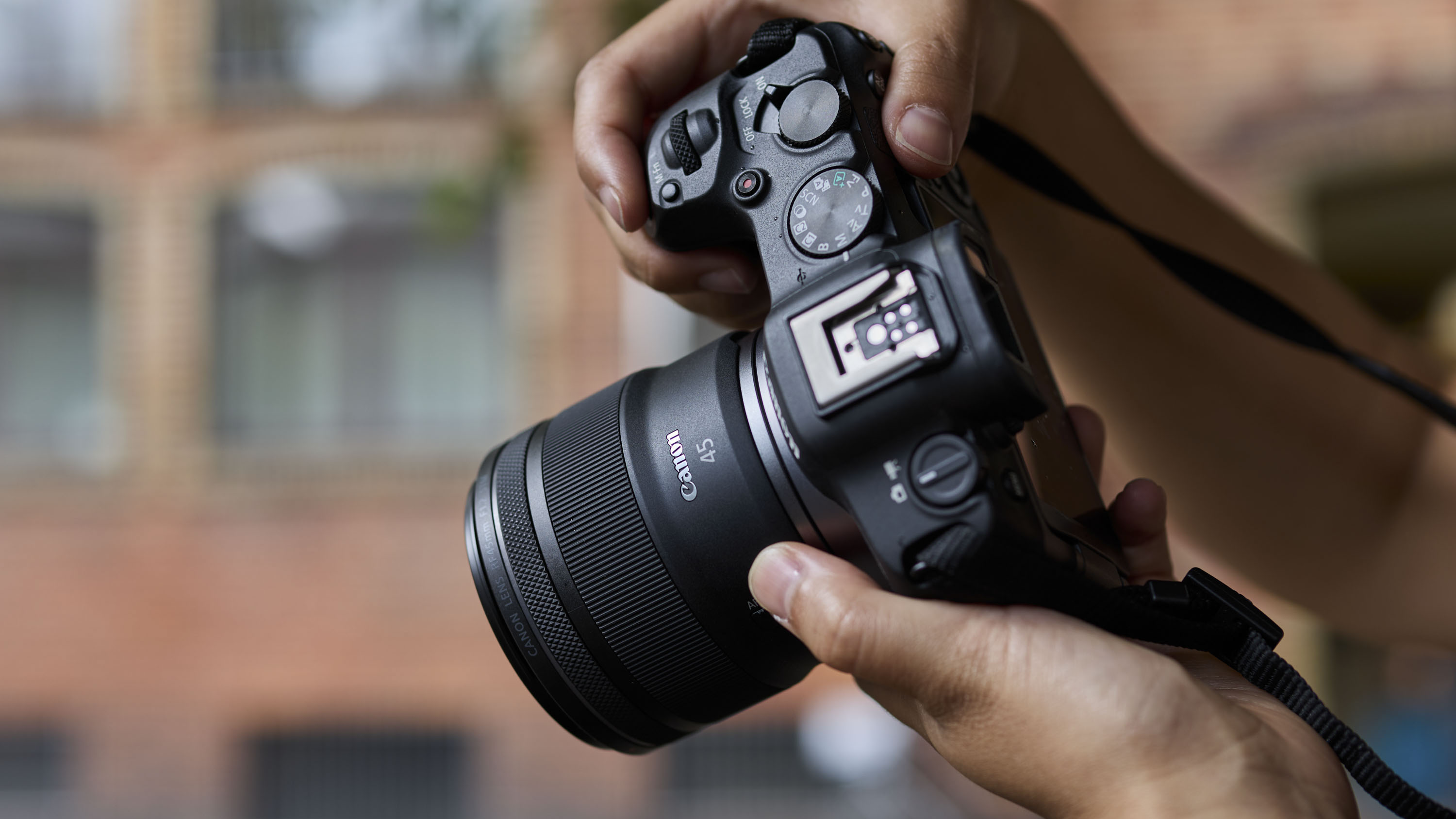 Canon RF 45mm F1.2 STM lens in the hand, attached to a Canon camera
