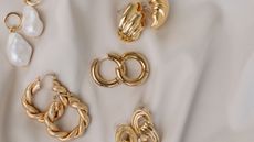Gold earrings on white background