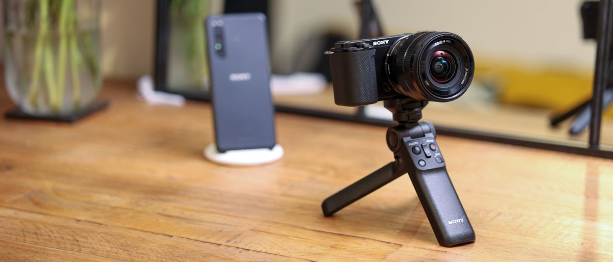 The Sony ZV-E10 on a mini tripod on a wooden table