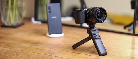 The Sony ZV-E10 on a mini tripod on a wooden table