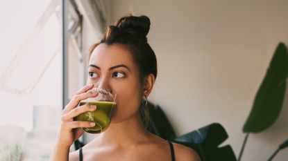 A woman drinking a green smoothie on a 7 day detox