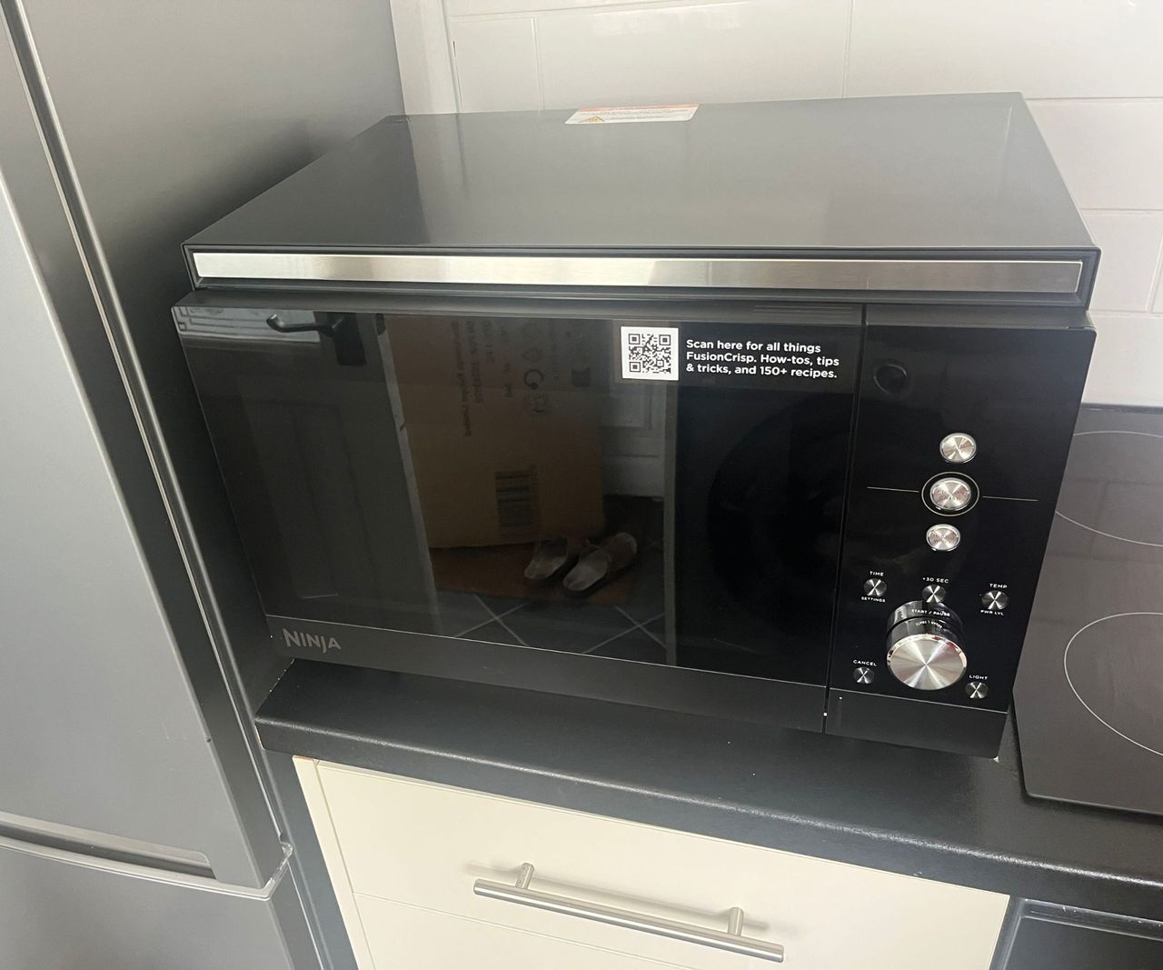 A black microwave on a kitchen counter