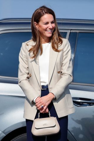 Kate Middleton wears a cream blazer and carries a matching bag as she arrives to meet those who supported the UK's evacuation of civilians from Afghanistan at RAF Brize Norton on September 15, 2021 in Brize Norton, England