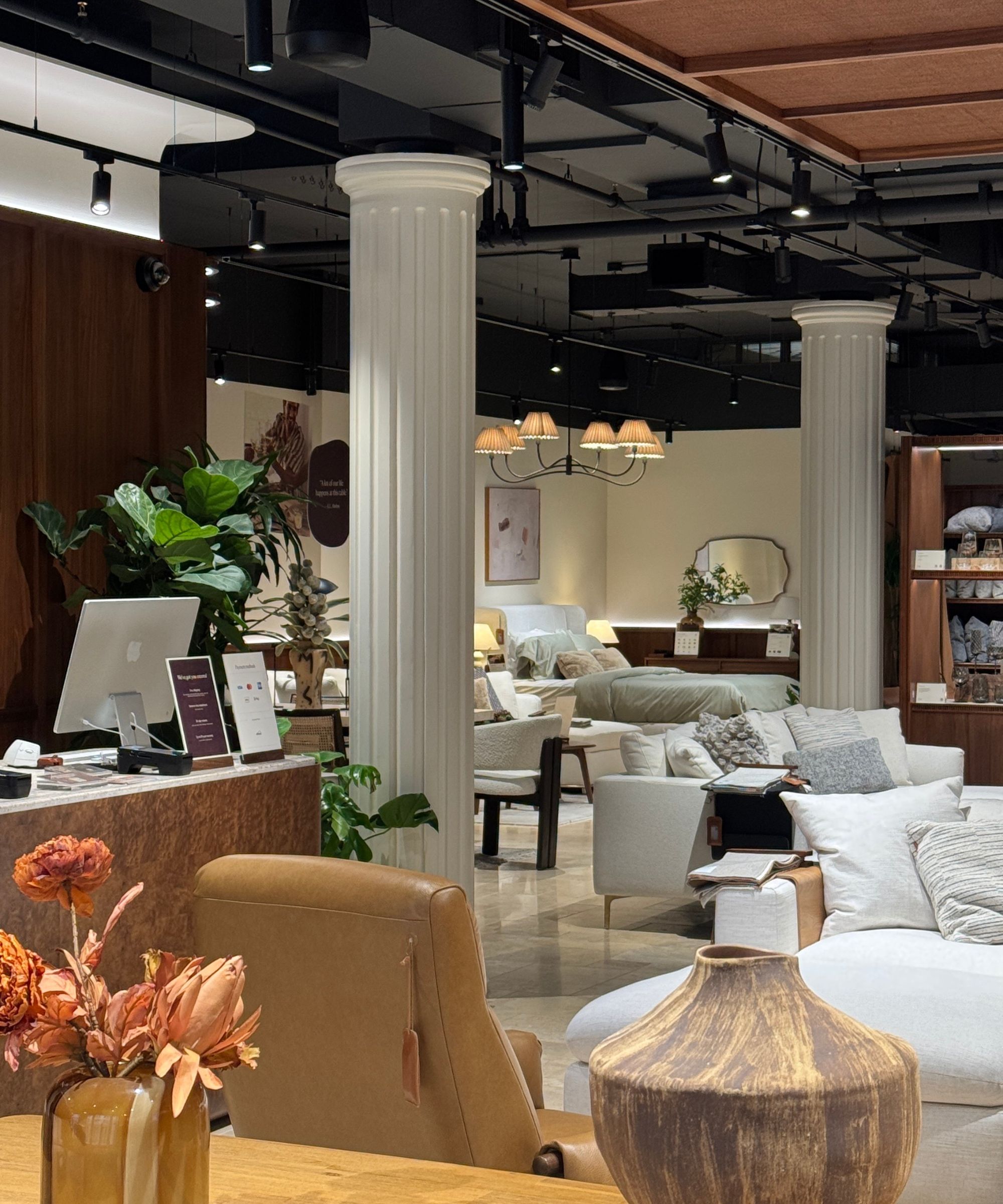 Castlery NYC Showroom with sofas, two columns, timber ceiling detail, cushions, and vases