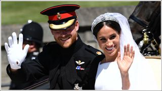 Britain's Prince Harry, Duke of Sussex and his wife Meghan, Duchess of Sussex wave from the Ascot Landau Carriage during their carriage procession on Castle Hill outside Windsor Castle in Windsor, on May 19, 2018 after their wedding ceremony