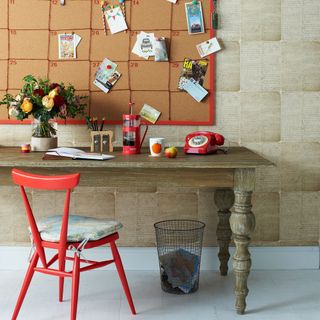 room with red board on wall wooden table and red chair