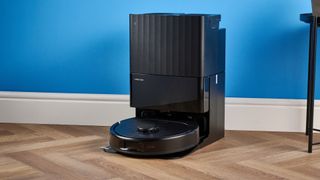 Roborock QV 35S with dock photographed in front of a blue background