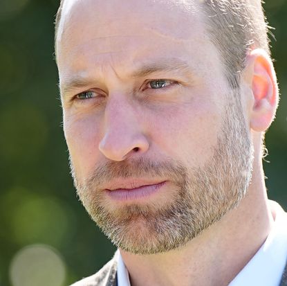 A headshot of Prince William wearing a white shirt and blazer looking thoughtful