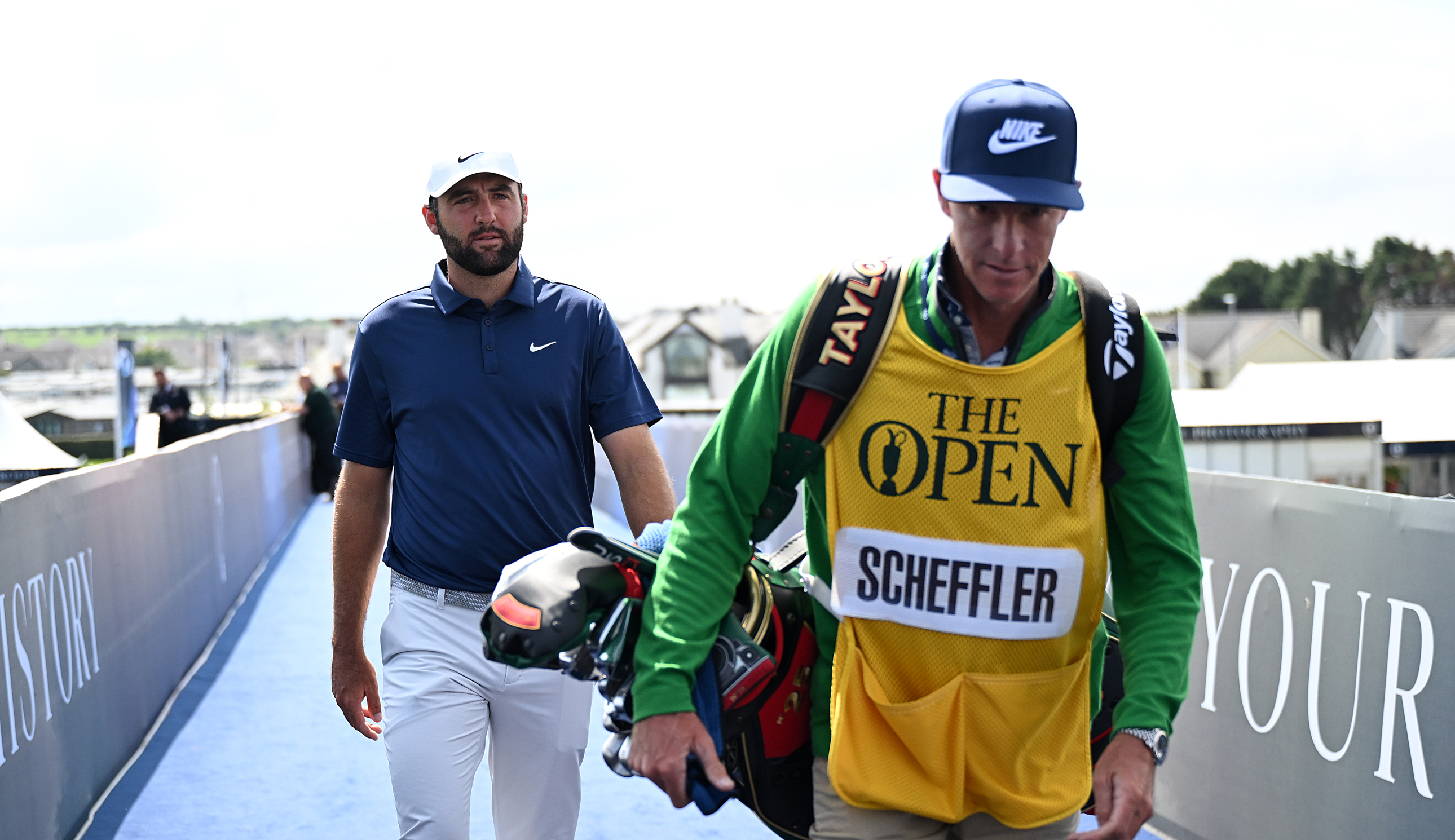 Scottie Scheffler walks to the first tee with caddie