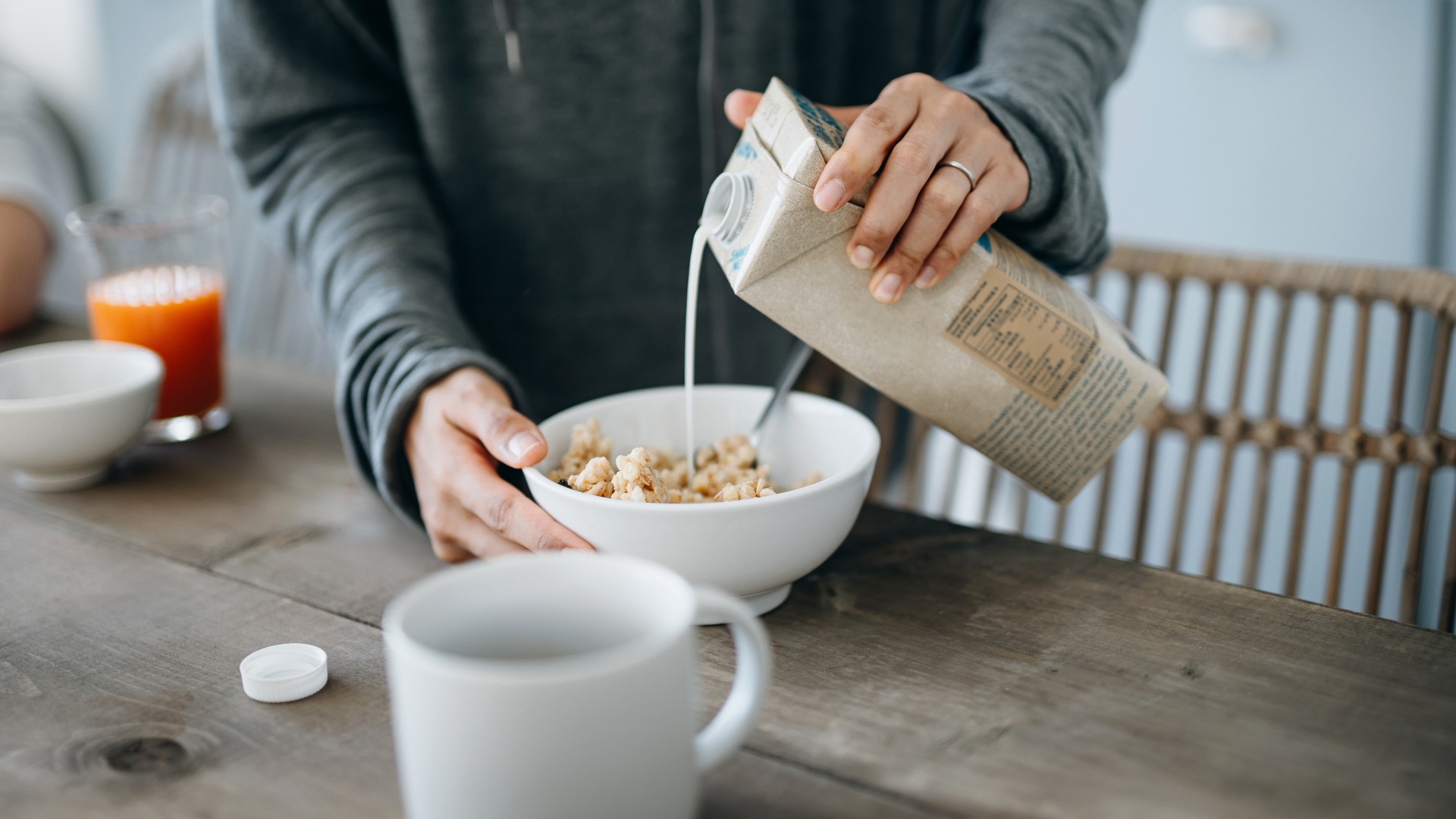 Woman pouring soy milk on cereal