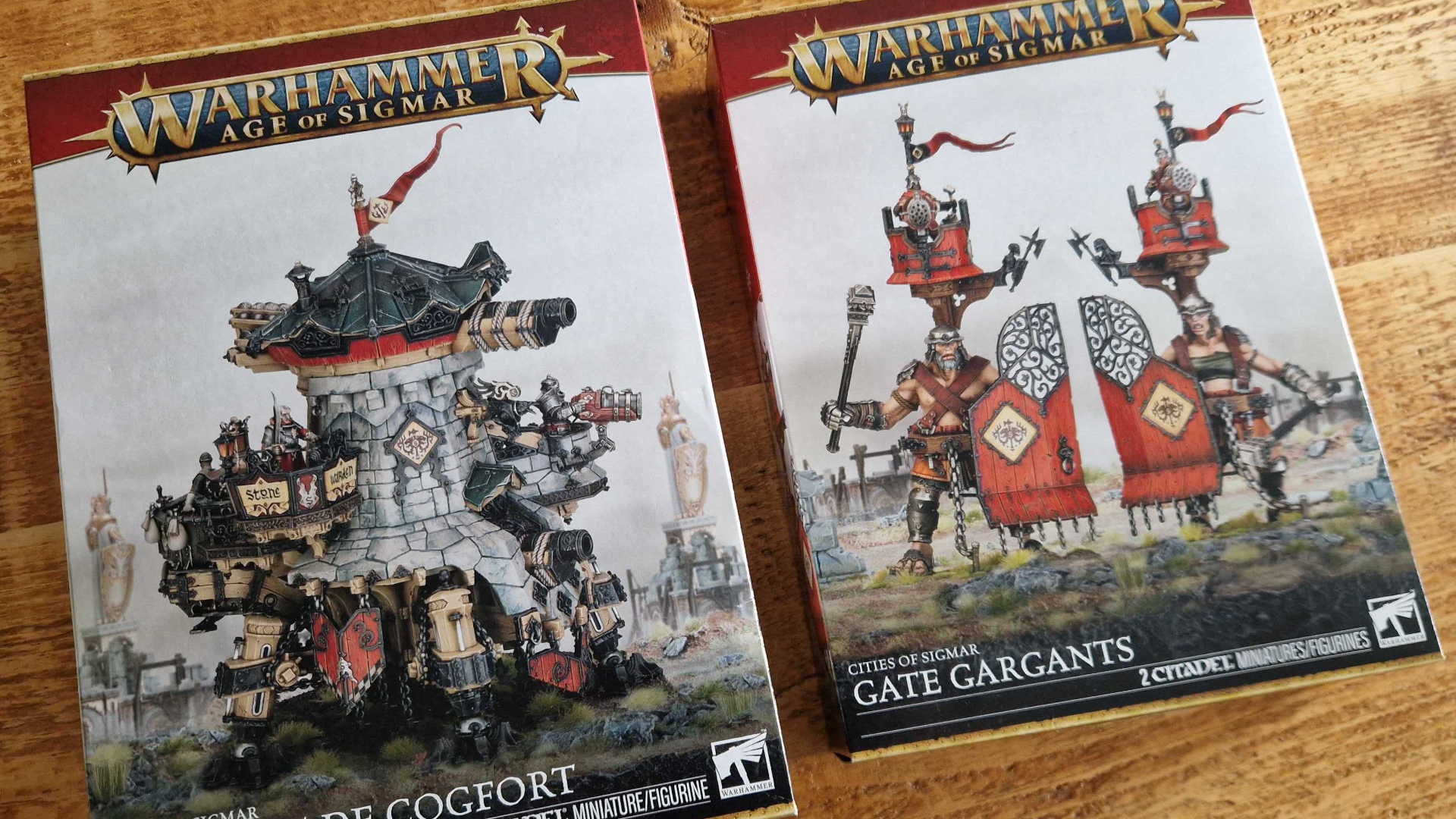 Cogfort and Gate Gargant boxes on a wooden table