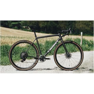 A black S-Works Crux stands on a gravel path