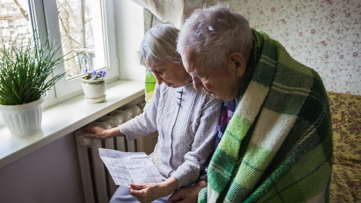 Woman holding cash in front of heating radiator. Payment for heating in winter.