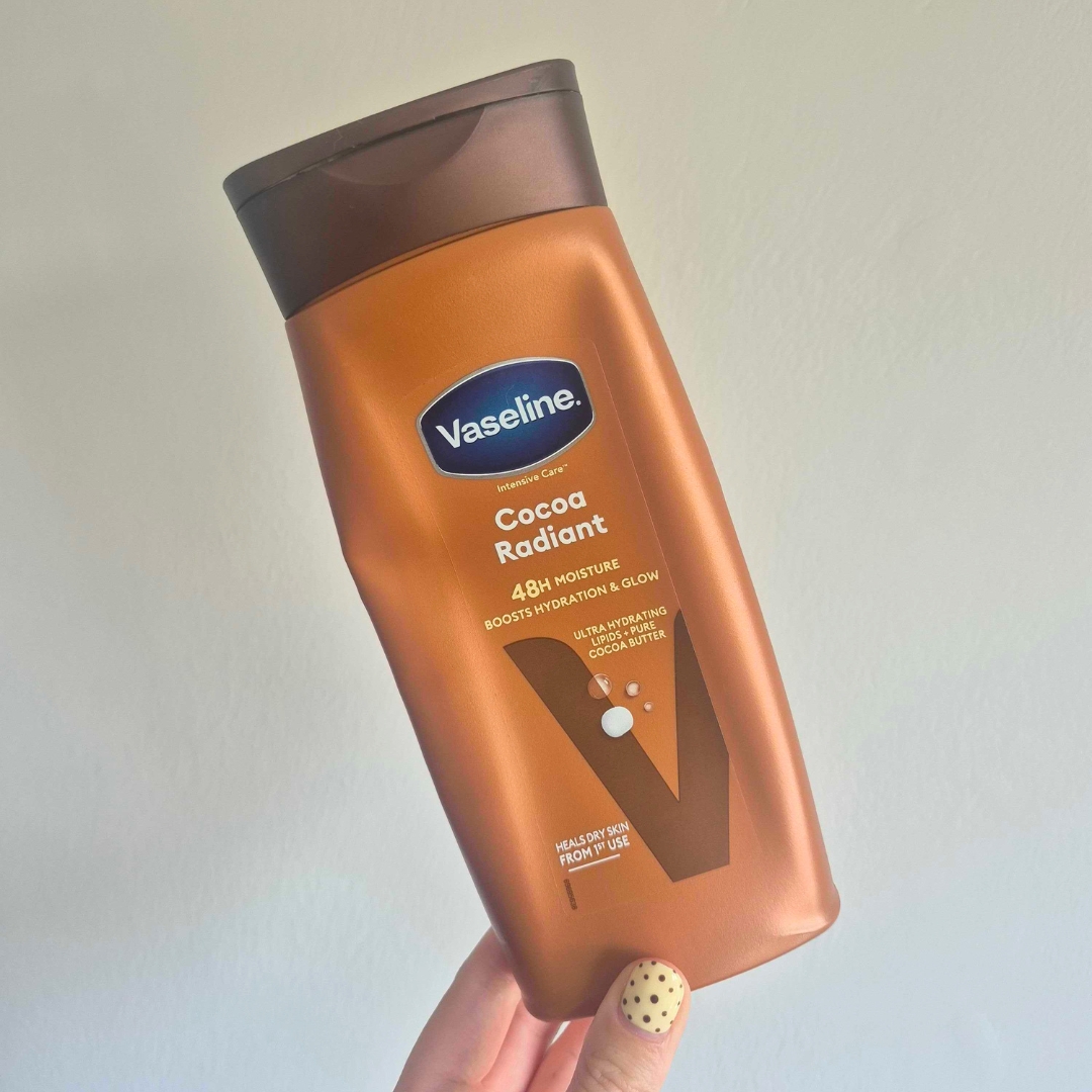 Hand holding an empty bottle of Vaseline Intensive Care Cocoa Radiant Body Lotion