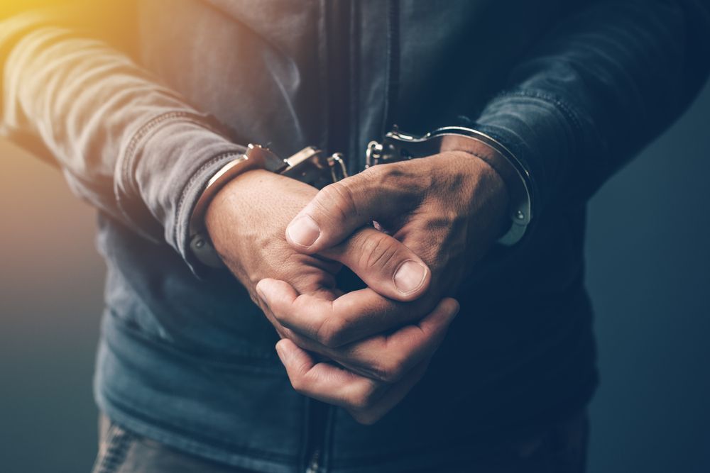 Closeup of a criminal&amp;#039;s wrists in handcuffs 