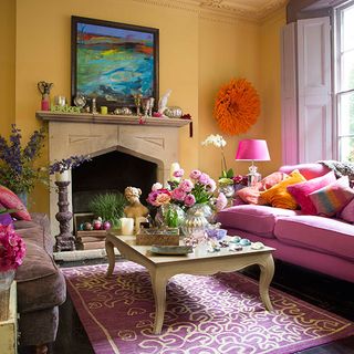 living area with yellow wall and fireplace and pinksofa