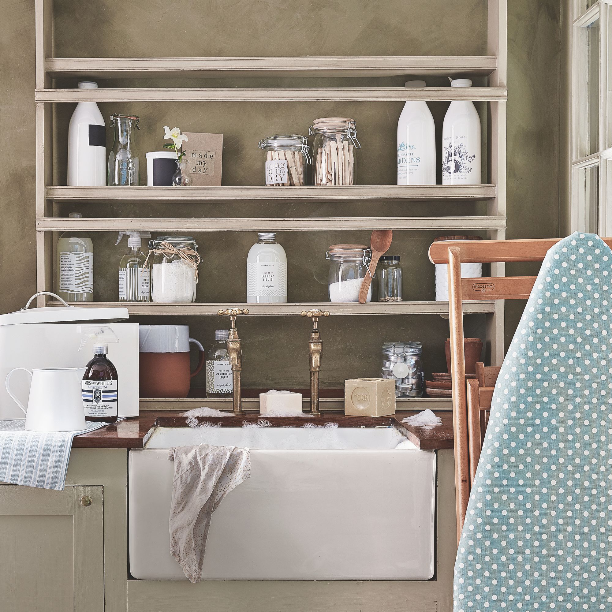 Utility room with shelves over a sink, full of cleaning products