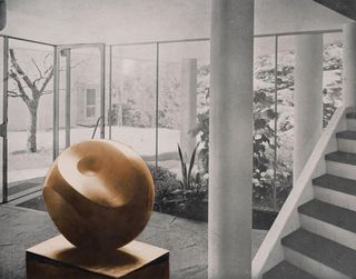 Large wooden spherical sculpture against a black and white backdropl