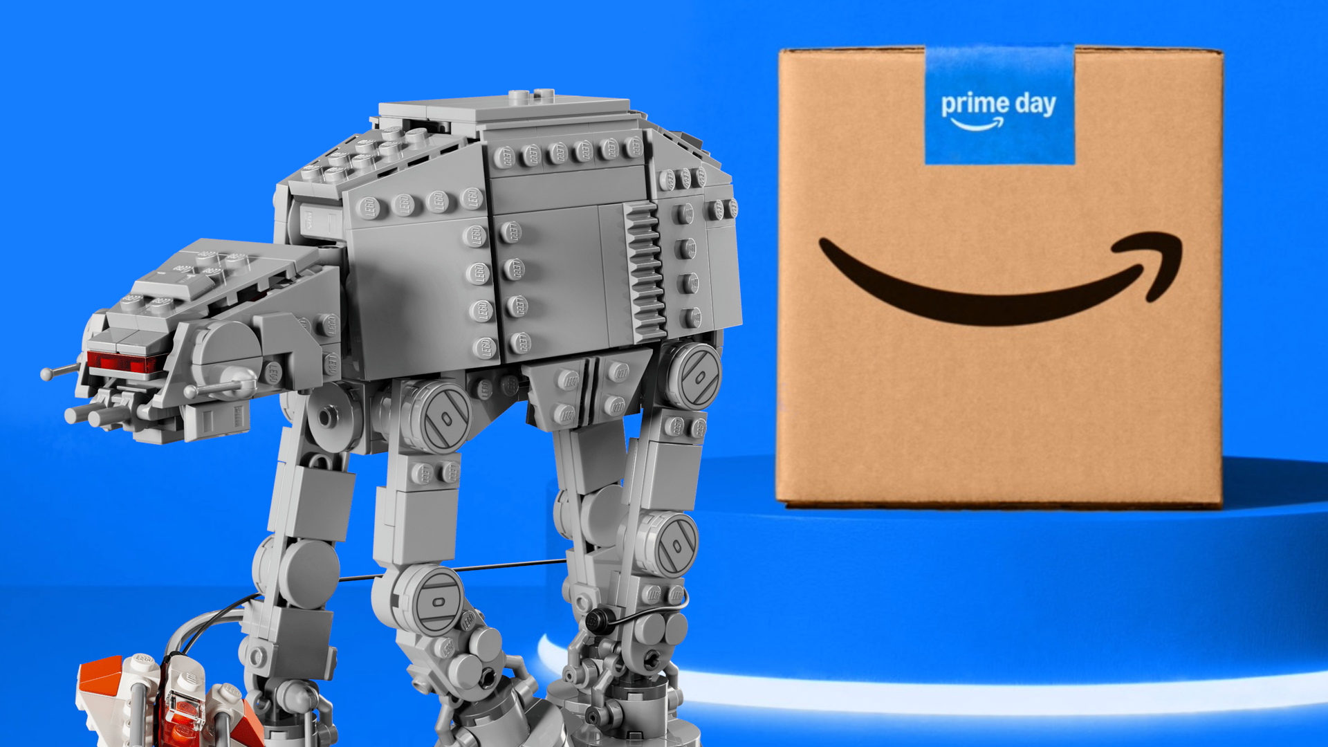 A Lego AT-AT model walks away from a Prime Day cardboard box, placed on a blue podium