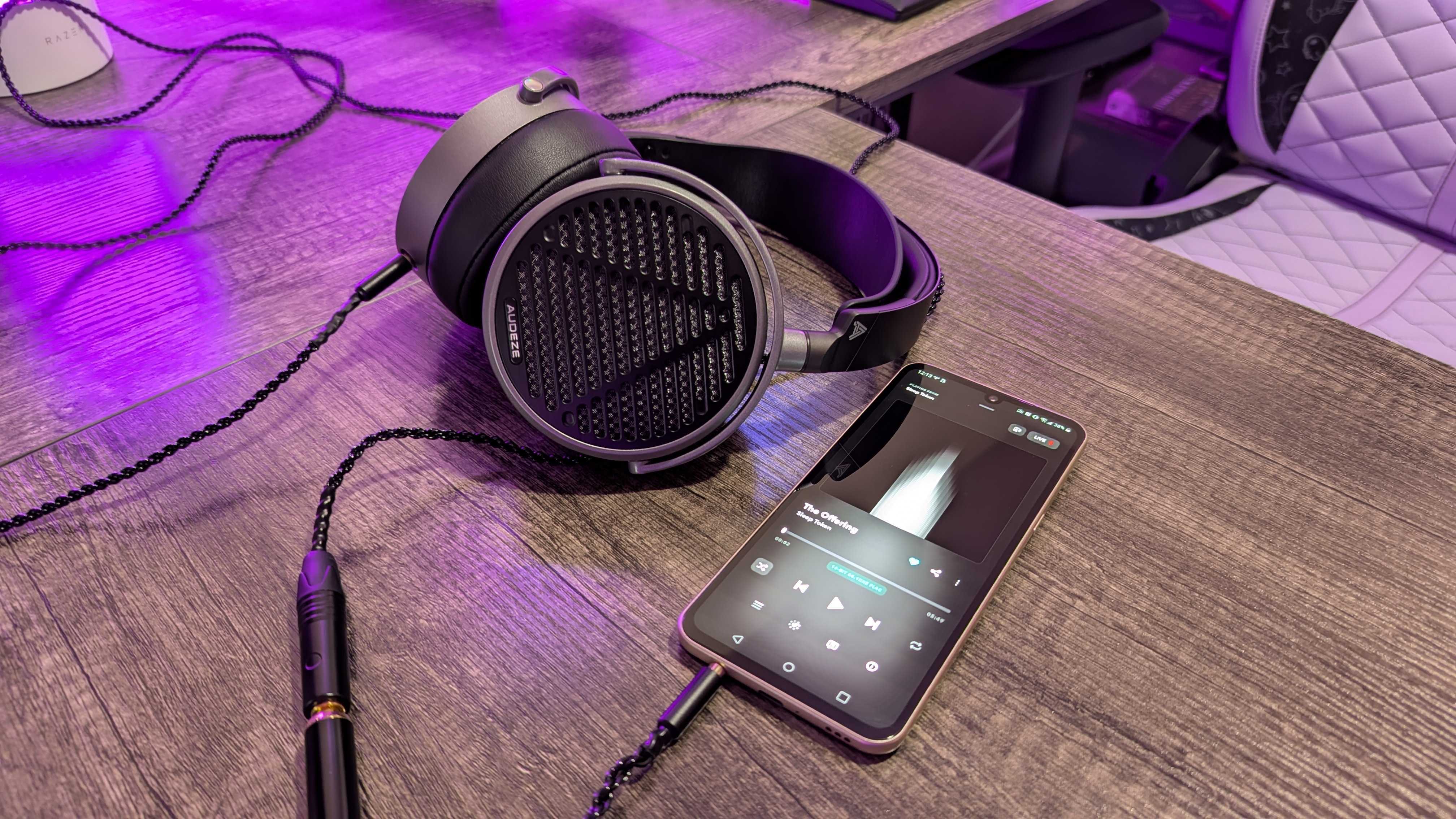 The Audeze MM-100 lying on a desk, plugged into an LG V60 ThinQ with TIDAL open.