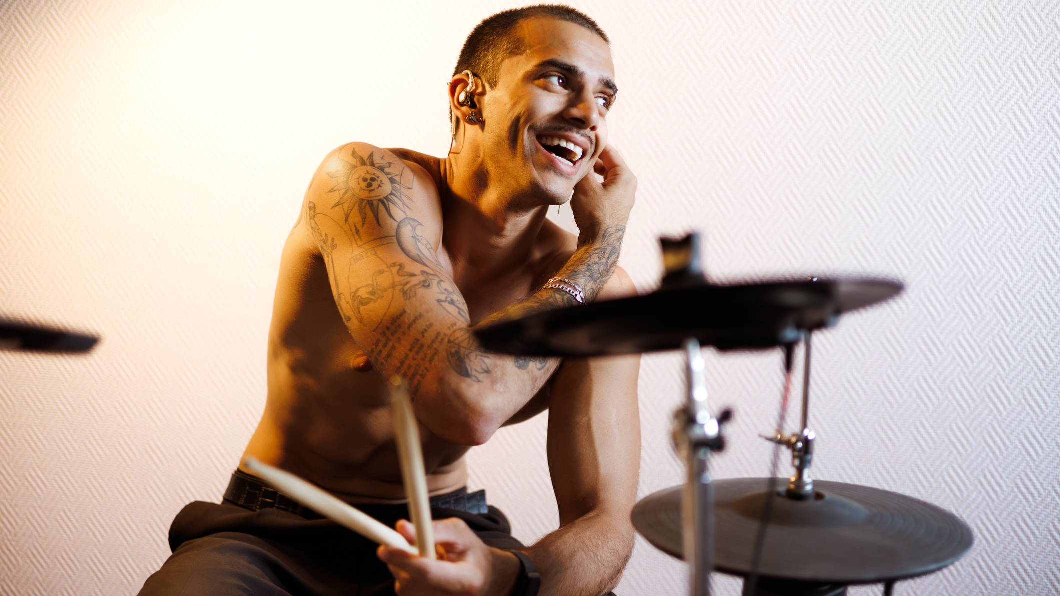 Smiling drummer inserting in-ear monitors