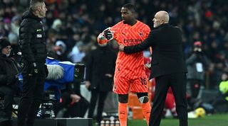 AC Milan goalkeeper Mike Maignan interacts with coach Stefano Pioli after receving racist abuse in a Serie A game at Udinese in January 2024.