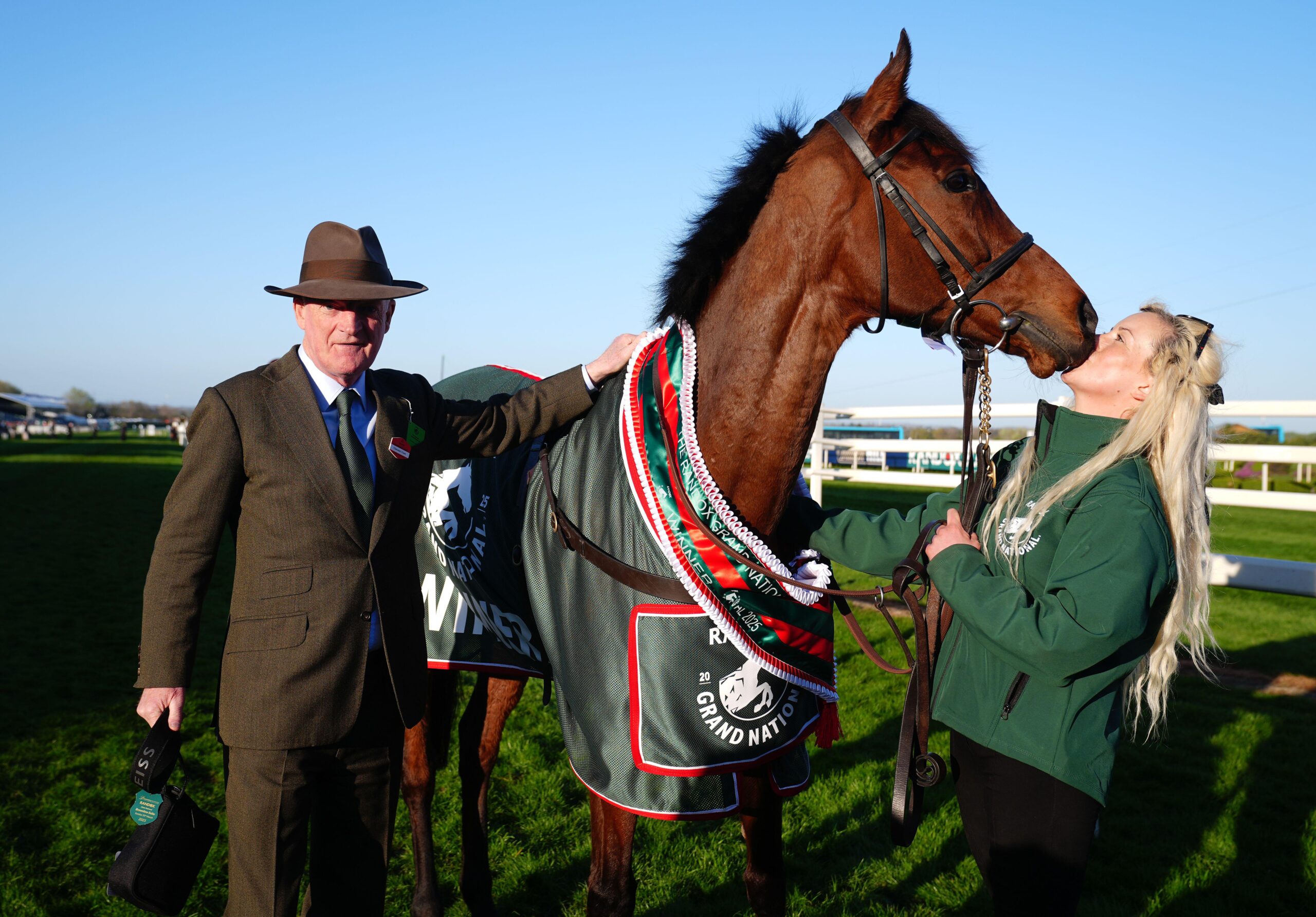 Trainer Willie Mullins with Grand National winner Nick Rockett and his groom Katie Walton on the evening of the race at Aintree racecourse.