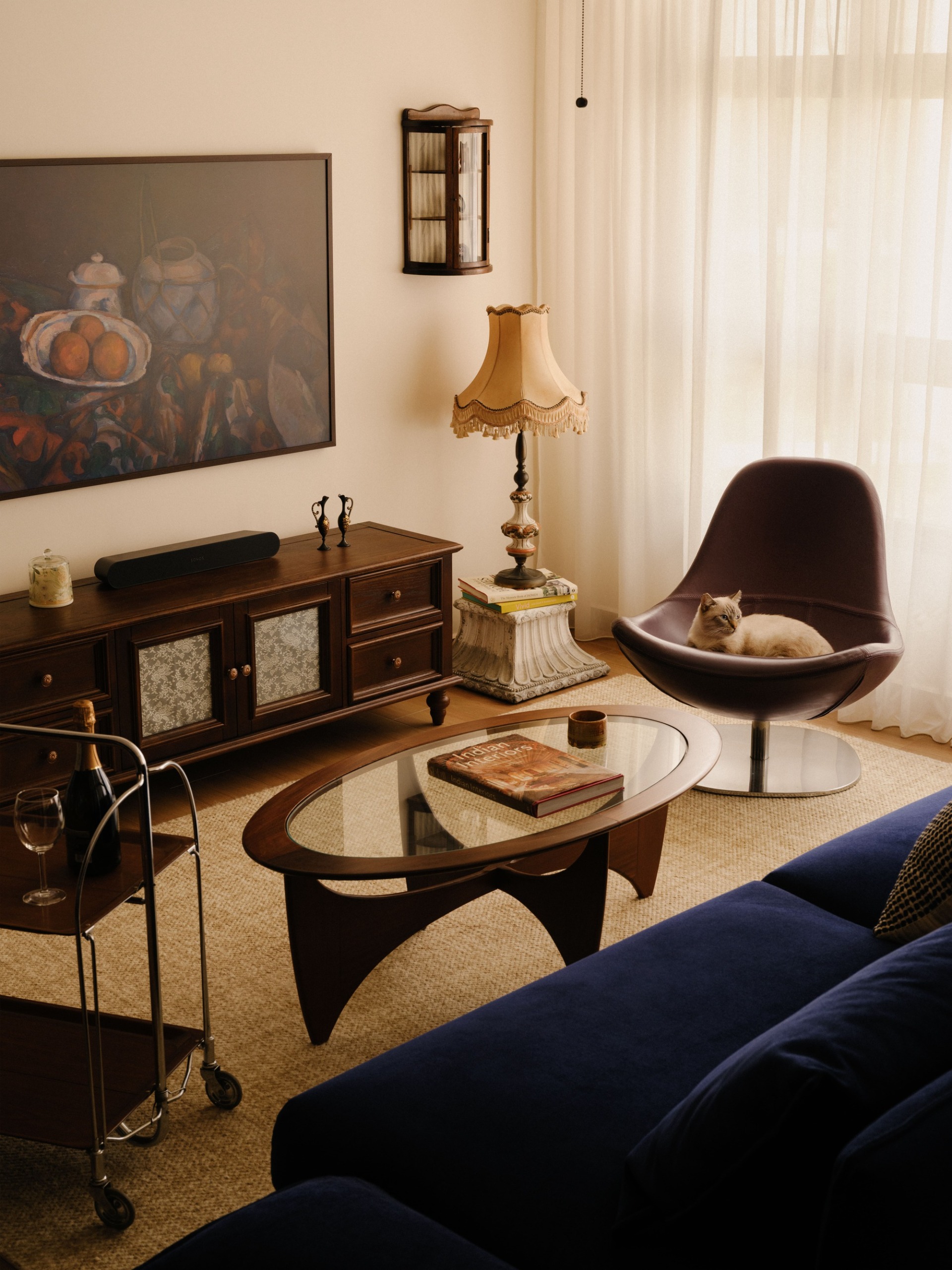 a living room with a blue velvet sofa and antique decor