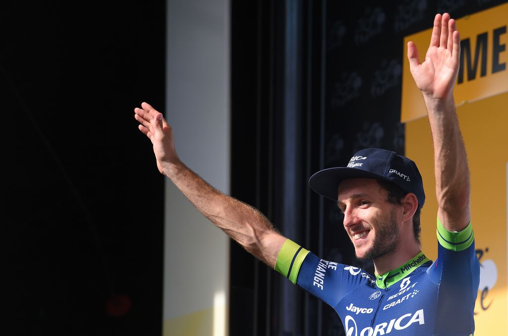 Adam Yates (Orica-BikeExchange) waves before receiving the white jersey